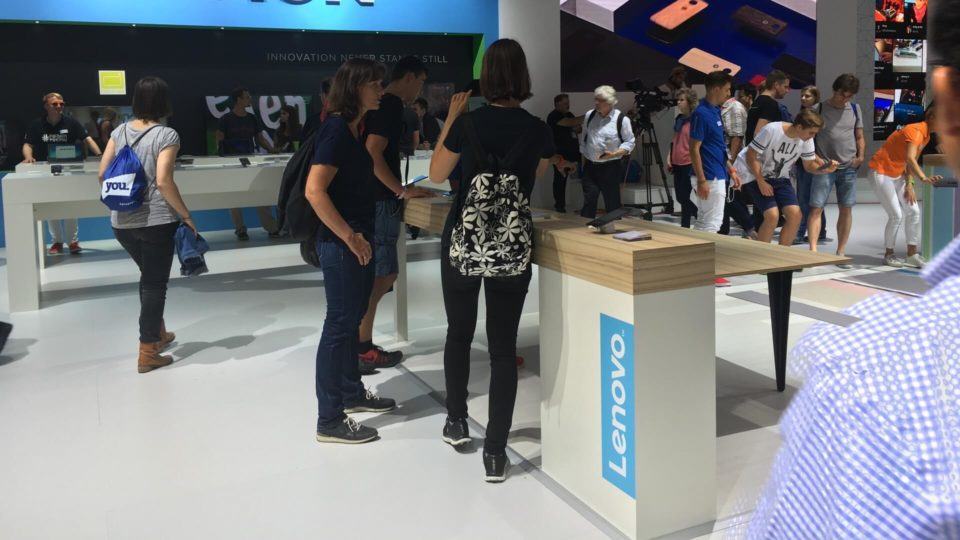 Visitantes mexem em smartphone da Lenovo.