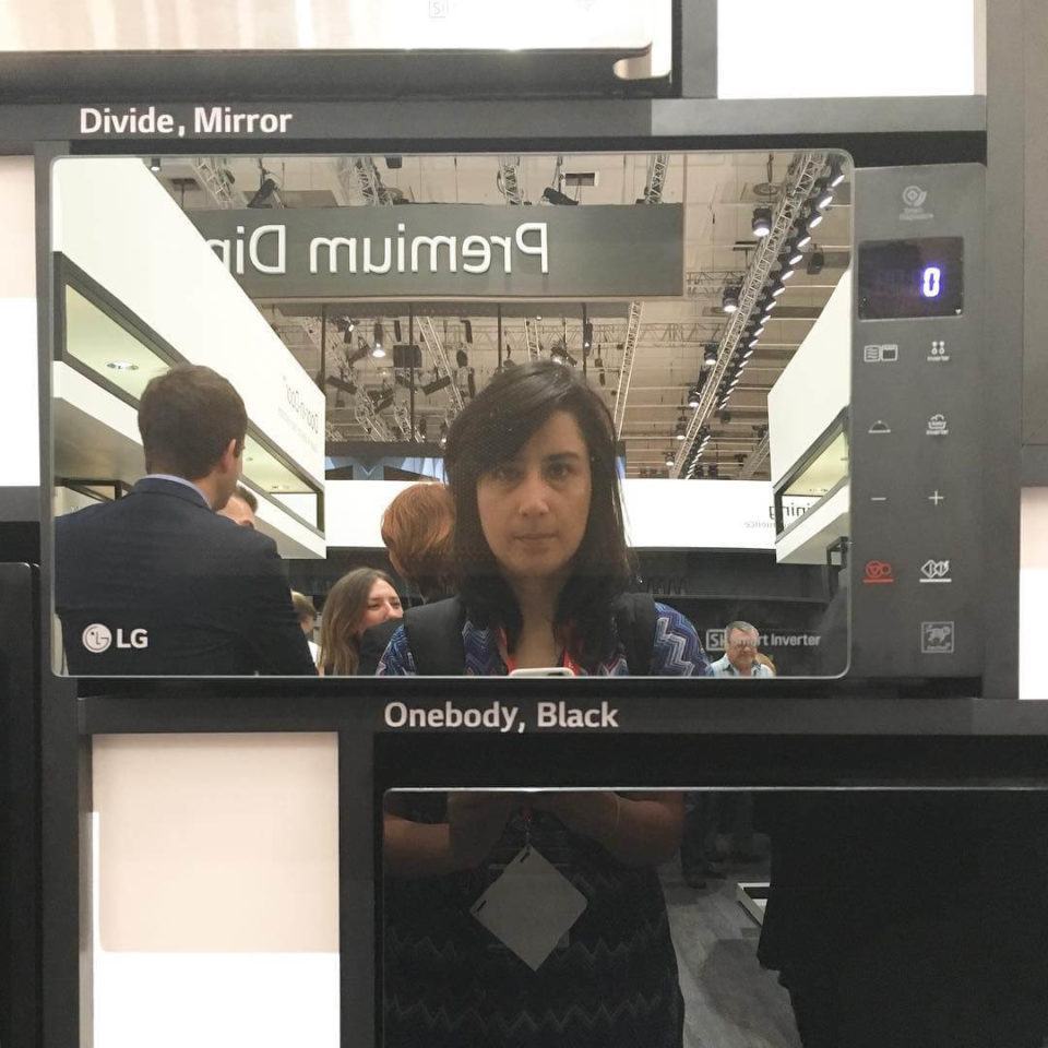 Emily tirando selfie na porta de um micro-ondas.