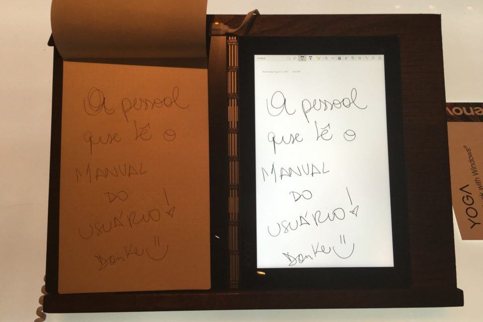 Folha de papel com texto escrito e replicado na tela do Yoga Book.